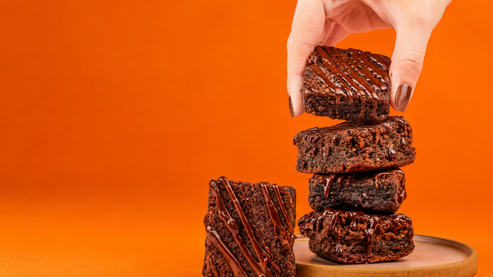 Brownies artesanais GiCandy empilhados com calda de chocolate